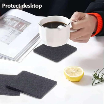 Filzuntersetzer in Schwarz schützt den Tisch, während eine Tasse Kaffee darauf steht.
